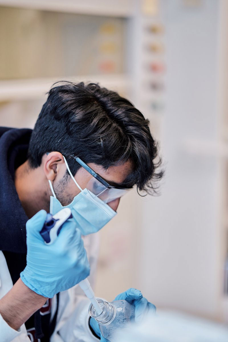 Candid of Orna employee pipetting in a lab