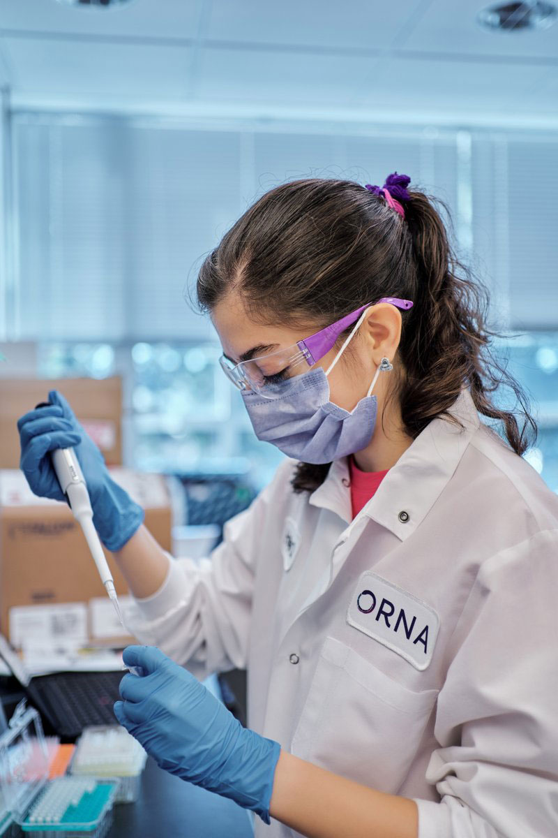 Candid of Orna employee pipetting in a lab